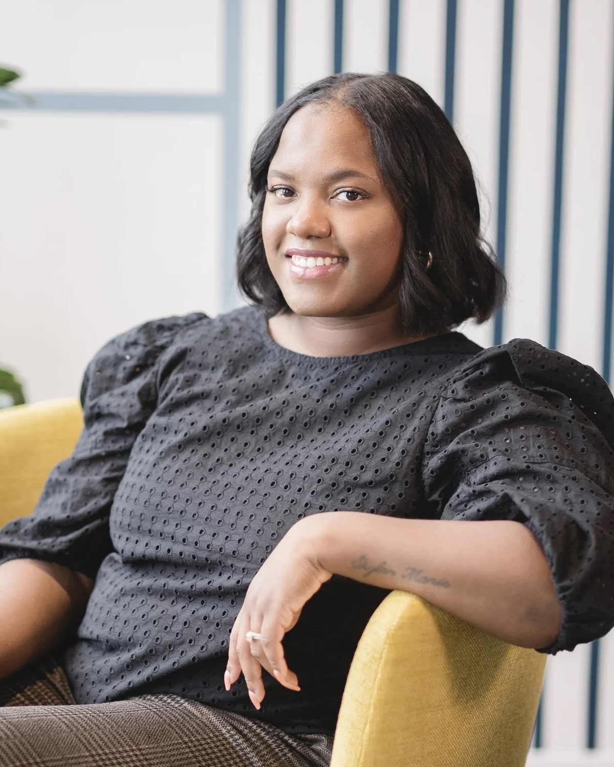 Shaquahia Biggs, LCSW, seated in an armchair in the Comfort Counseling office